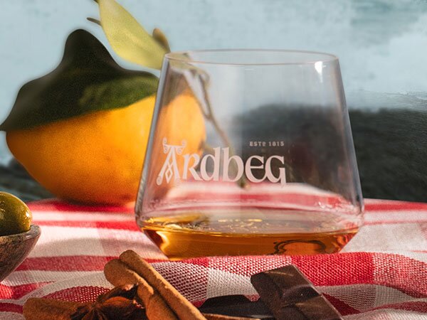 An Ardbeg glass on a checked table cloth.