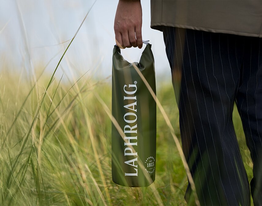 Laphroaig branded dry bag Gift with purchase being help in grass