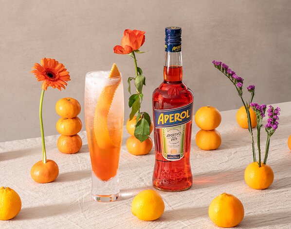 A bottle of Aperol with an Aperol Spritz Paloma next to it.