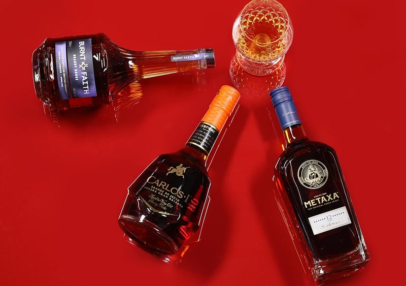 Three Brandy bottles on a red background.