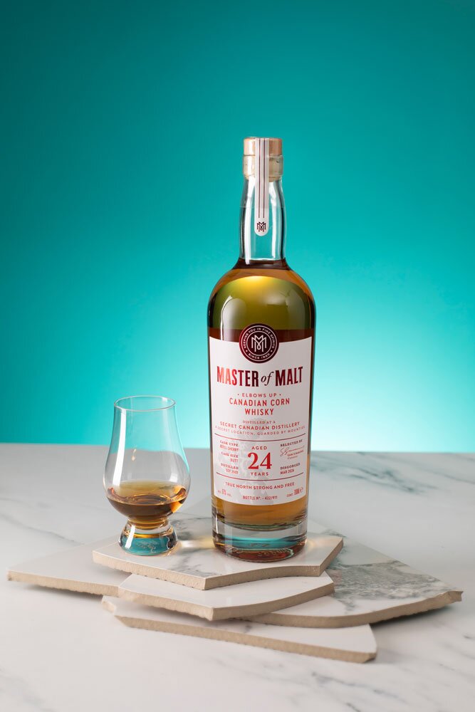 A Secret Canadian Distillery 24 Year Old - Elbows Up Edition (Master of Malt) whisky bottle with tasting glass