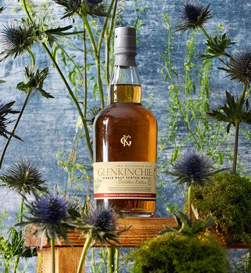 A bottle of Glenkinchie Distillers Edition surrounded by thistles. 