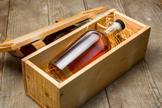 Bottle of whisky in an oak box packed with straw.