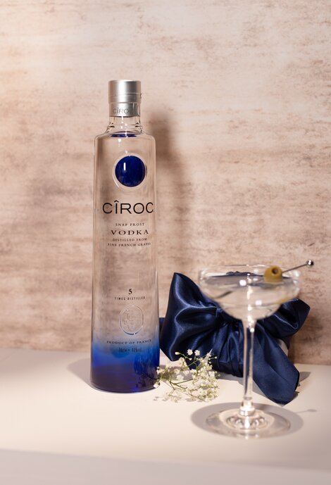 A bottle of Cîroc vodka against a pink and beige background. 