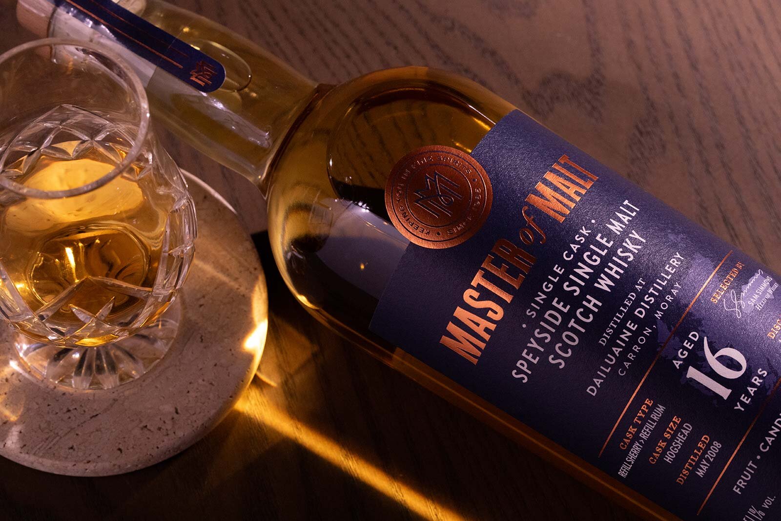 Close up of a Master of Malt Whisky bottling next to a poured glass of whisky.