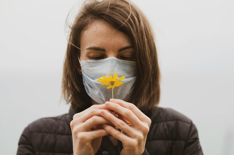 Woman with facemask who is allergic to a flower