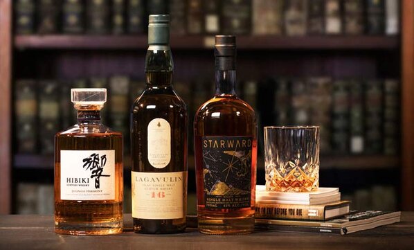 Bottles of Hibiki, Lagavulin, Starward and a glass of whisky.