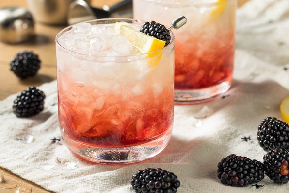 A gin Bramble cocktail garnished with fresh blackberries.