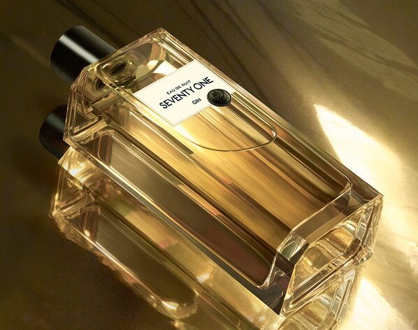 A bottle of SEVENTY ONE Gin on a golden surface.