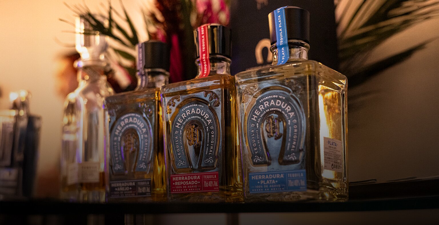 Three bottles of Herradura tequila on a bar