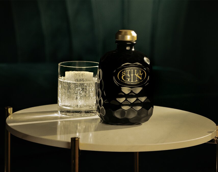 A bottle of Still G.I.N next to a cocktail.
