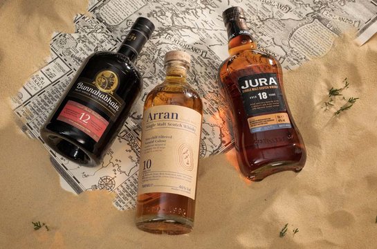 Three bottles Scotland map with sand