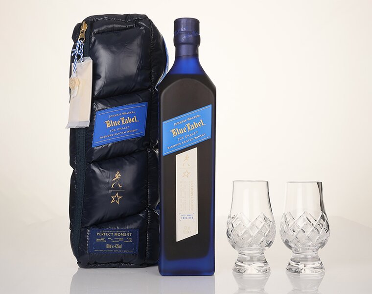 A bottle of Johnnie Walker Blue Label Ice Chalet with it's branded bag and two crystal cut glasses.