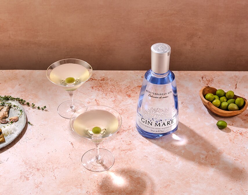 A bottle of Gin Mare next to martini cocktails.