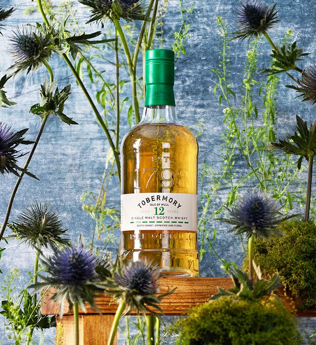 A bottle of Tobermory 12 Year Old surrounded by thistles. 