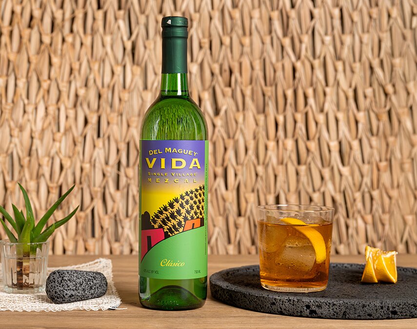 A bottle of Del Maguey Mezcal Vida next to a negroni cocktail.