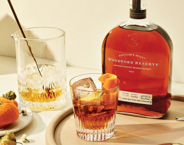 A bottle of Woodford Reserve and Old Fashioned cocktail. 