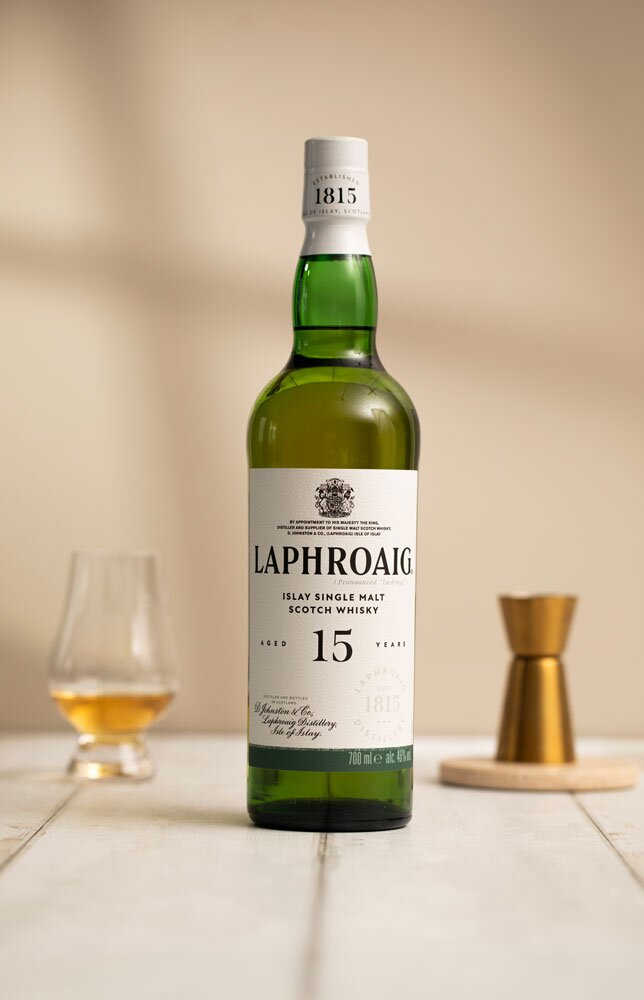 Laphroaig 15 Year Old whisky bottle in front of Glencairn glass and jigger