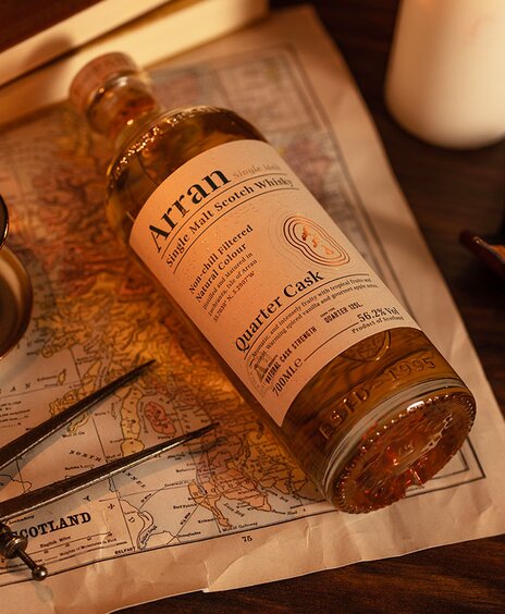 A bottle of Arran the Bothy on top of a map of Scotland. 