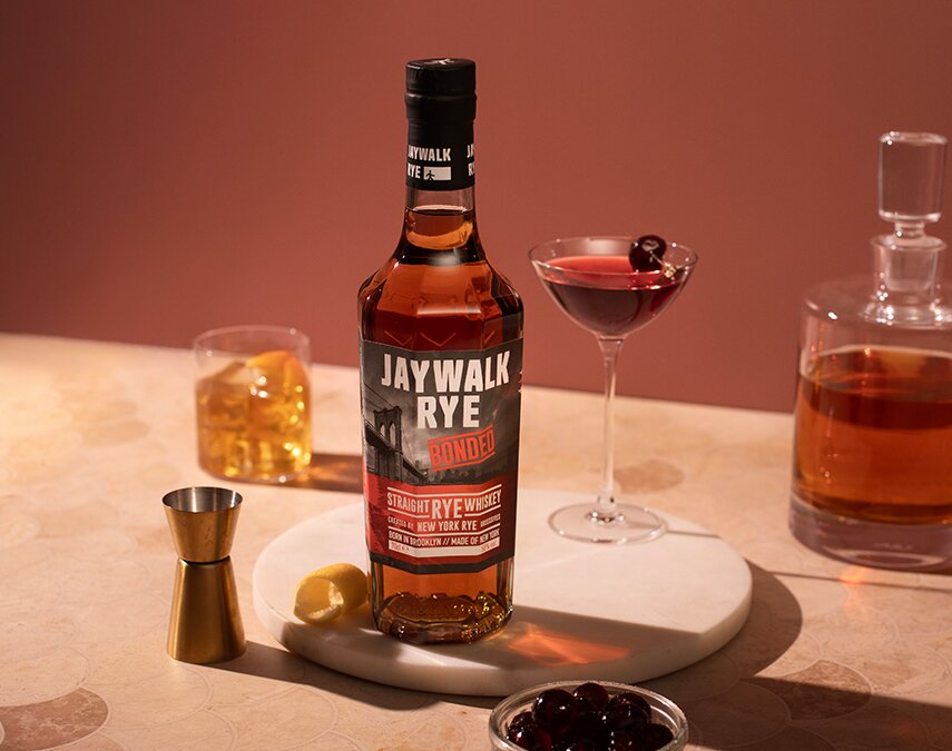 A bottle of Jaywalk Bonded Rye Whiskey and a Manhattan.