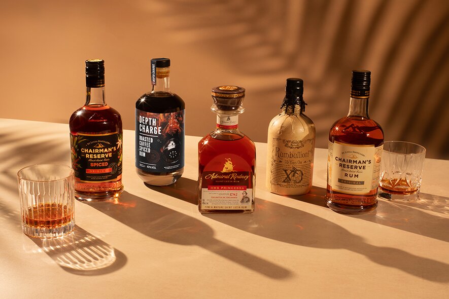 Five bottles of rum with a tropical palm shadow.