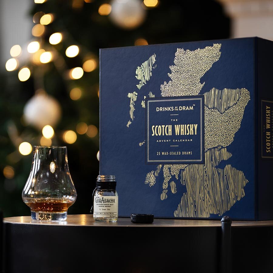 A scotch Whisky advent calendar next to a dram poured into a glass