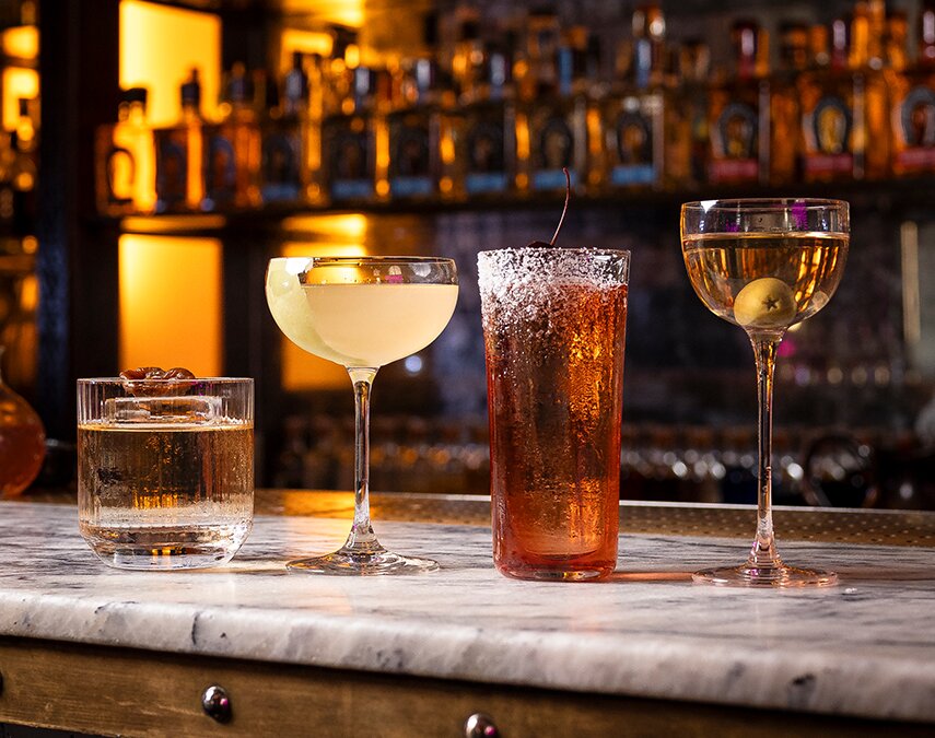 Four cocktails on a bar