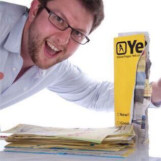 Justin triumphant beside a torn in half Yellow Pages phone directory