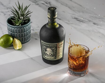A bottle of No.3 Gin with a gin martini cocktail on the right of it.  