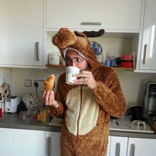 Sam Simmons dressed as a reindeer in the office kitchen