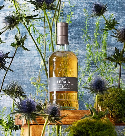 A bottle of Ledaig 10 Year Old surrounded by thistles. 