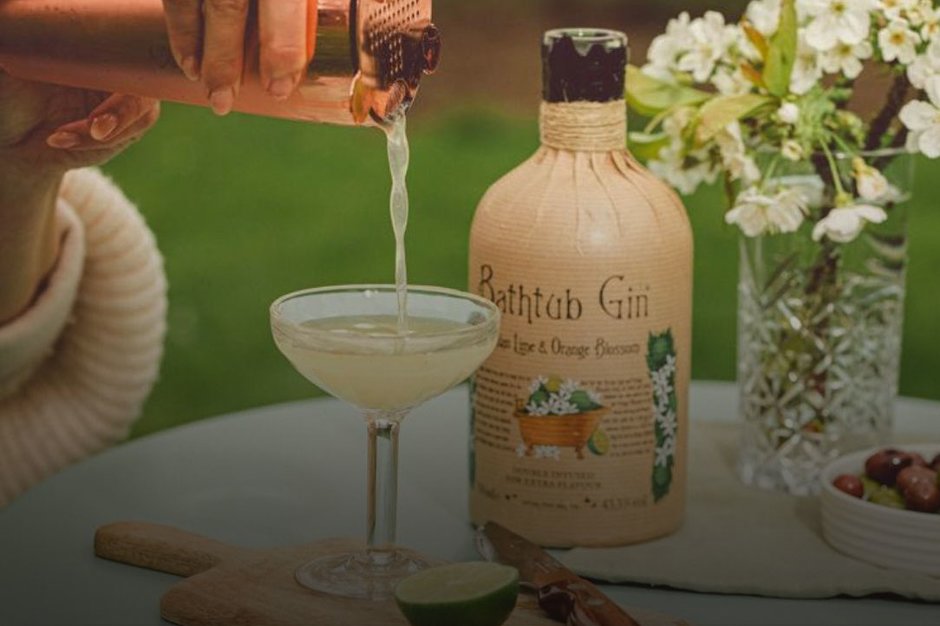 A bottle of Bathtub gin with a cocktail on a garden table.