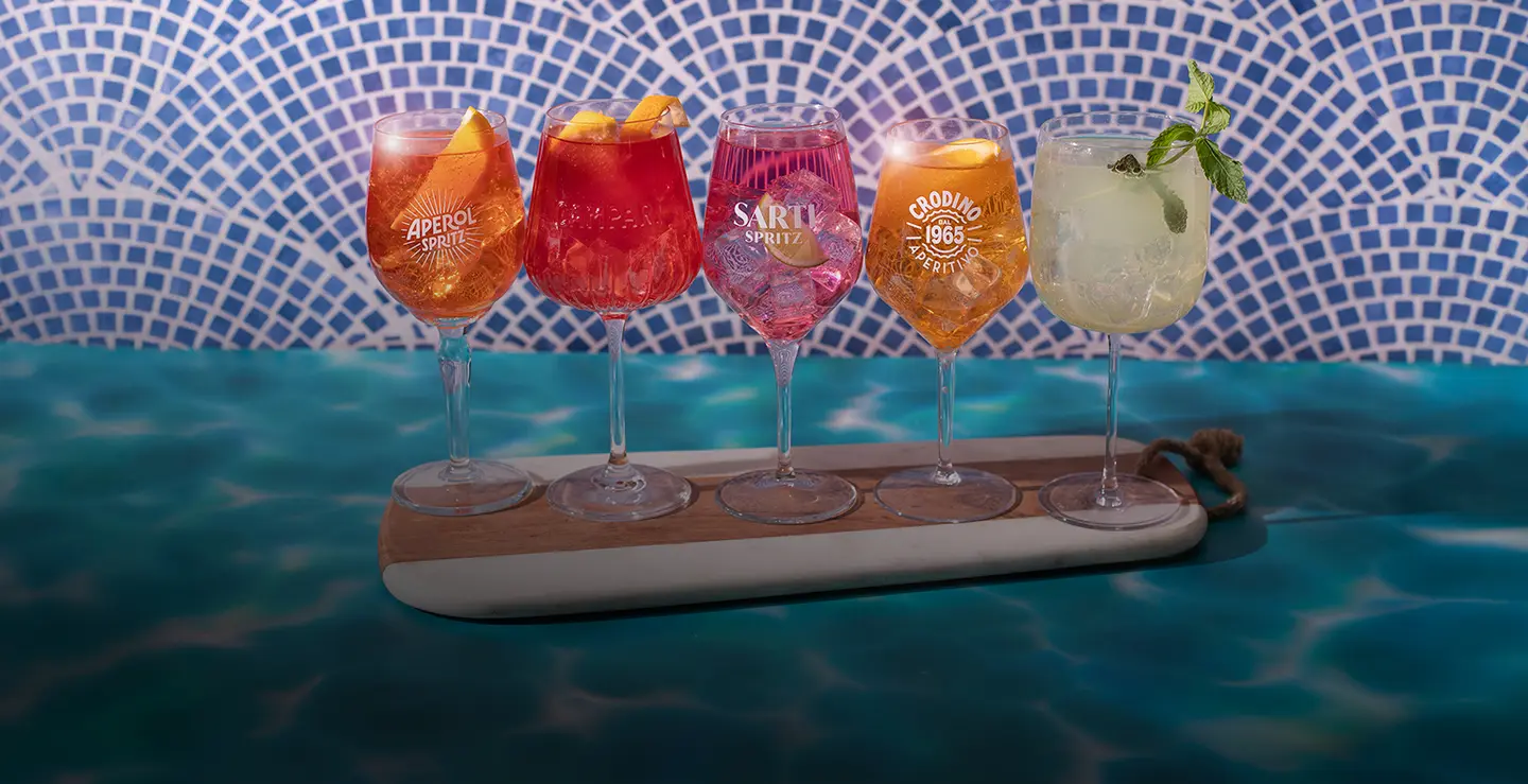 Five spritzes, made with Aperol, Campari, Sarti Rosa, Crodino, and Mondoro.
