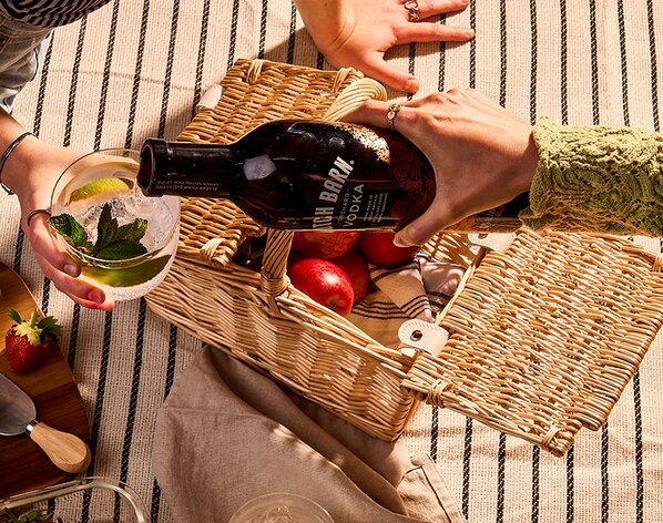 A bottle of Dutch Barn Orchard Vodka being poured at a picnic
