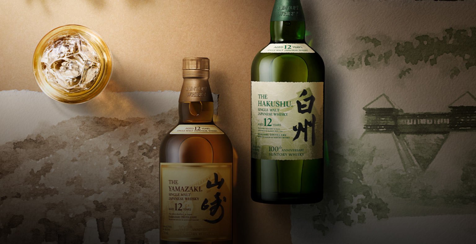 Two bottles of Whisky laying on top of Japanese water colour paintings.