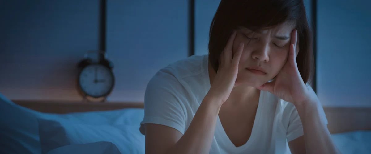 Woman who can't sleep sitting up in bed