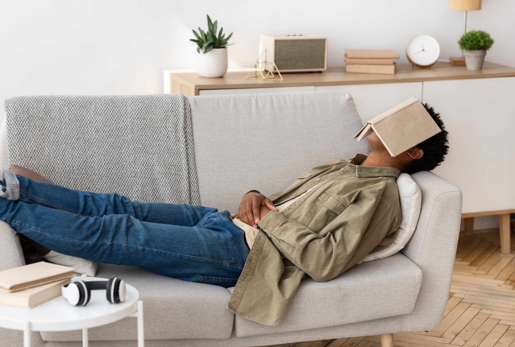 Man napping on couch with book on his face