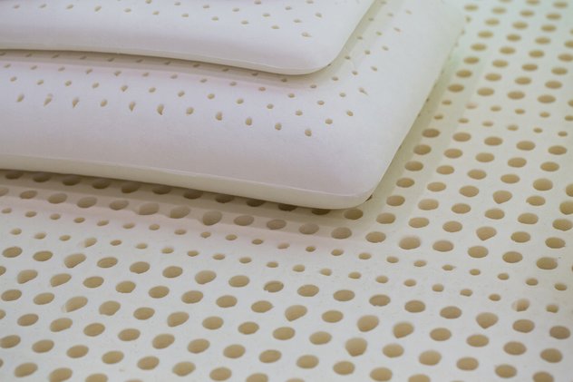Two latex pillows stacked on top of a latex mattress