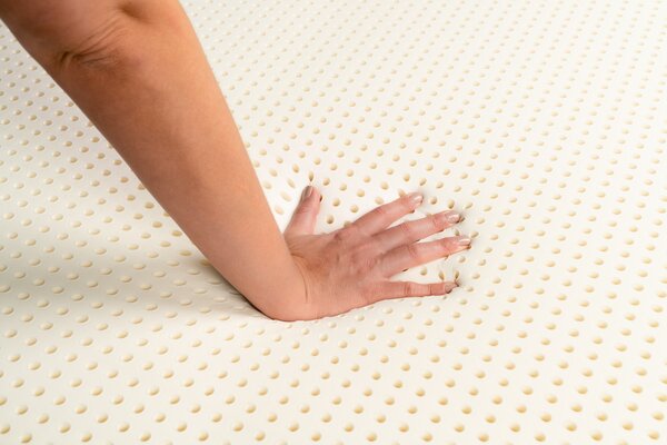 Hand pressing on latex mattress topper 