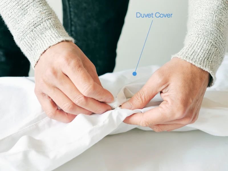 Man buttoning a duvet cover