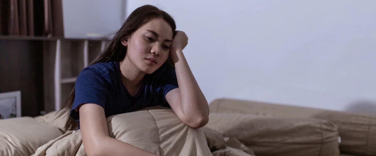 Young woman who can't sleep sitting up in bed