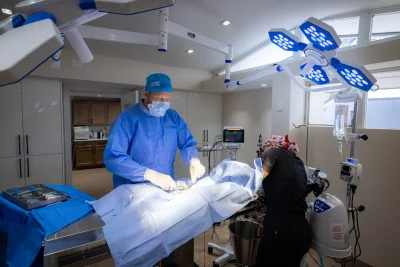 Veterinarian in surgical suite performing pet dental procedure with modern equipment and surgical lights at Skyway Animal Hospital, St. Pete