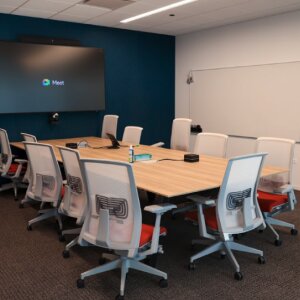 Table, chairs, and digital screen in a corporate meeting room