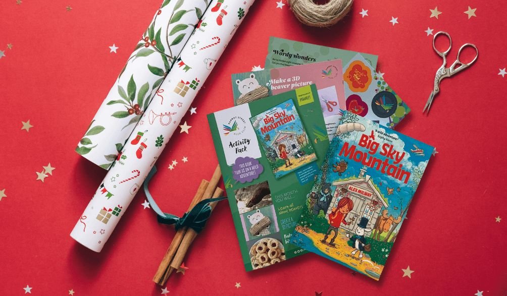Parrot Street Book Club book and activity pack laid out with Christmas wrapping
