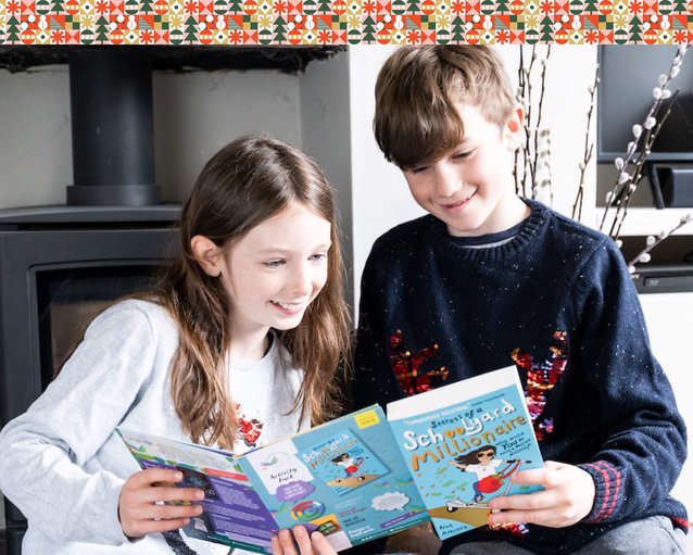 Two children looking at a Parrot Street Book Club children's book subscription box