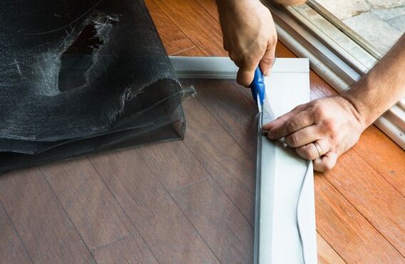 handyman repairing window screen