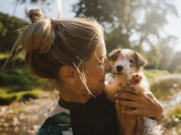 A woman holding a small puppy