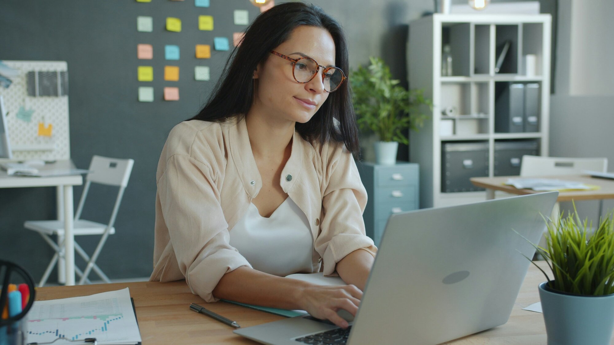 Woman in glasses typing on a laptop