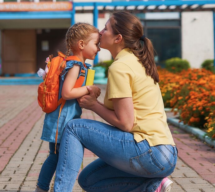 A parent comforting a child before school