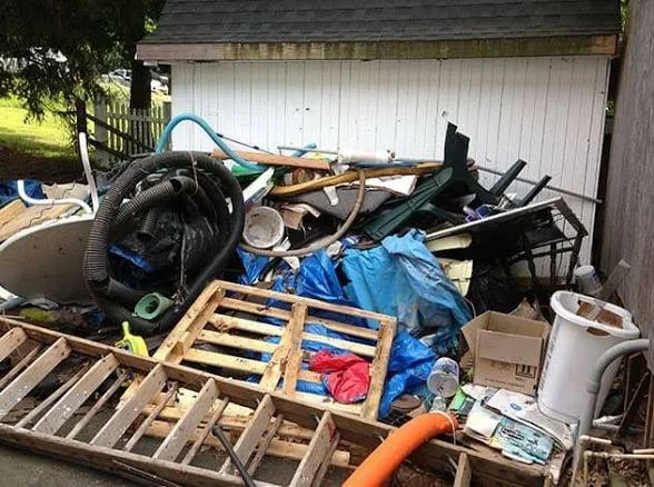 Pile of outdoor clutter and discarded items before cleanup
